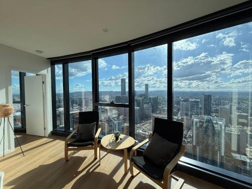 a room with two chairs and a table and a large window at Amazing City &River views 60th level skytower 3 bedrooms&Free parking in Brisbane