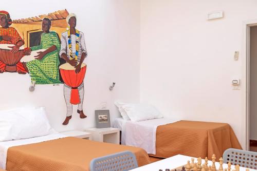 a room with two beds and a painting on the wall at A Casa di Amici in Palermo