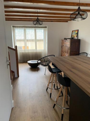 - un salon avec une grande table et des chaises en bois dans l'établissement Les fleurs d Aubrac, à Nasbinals