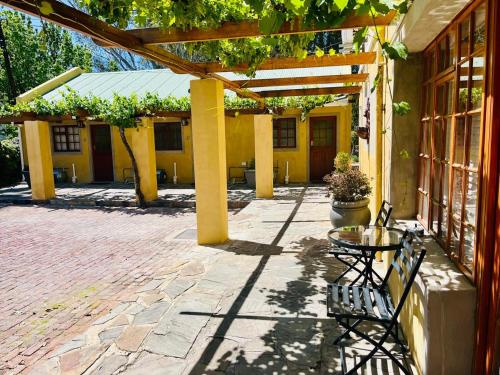 a patio with a table and chairs in front of a building at 17 on Bird Guest House in Beaufort West