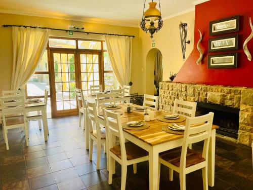 a dining room with a table and a fireplace at 17 on Bird Guest House in Beaufort West