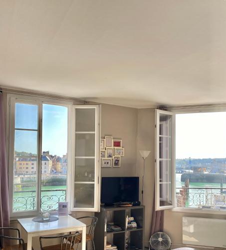 un salon avec deux fenêtres et une table et une télévision dans l'établissement VUE PORT 