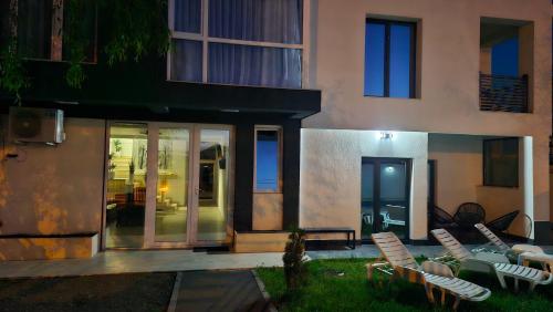 a group of chairs sitting in a yard next to a building at Casa Damian DROBETA in Drobeta-Turnu Severin