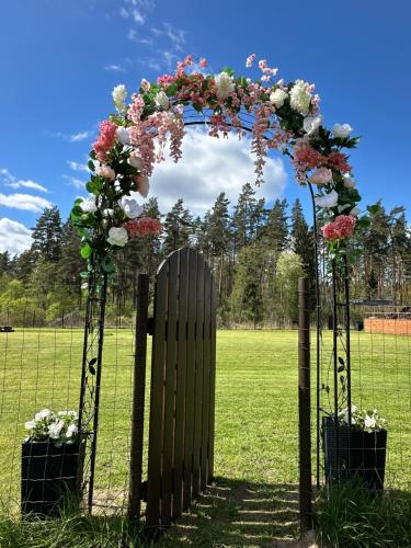 an arch with flowers on it in a field at Grisli glempings in Gauja