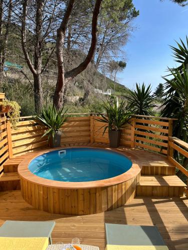 a hot tub on a wooden deck with plants at Wild Wild Nest Sperlongaresort in Sperlonga