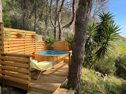 a wooden deck with a hot tub and a tree at Wild Wild Nest Sperlongaresort in Sperlonga