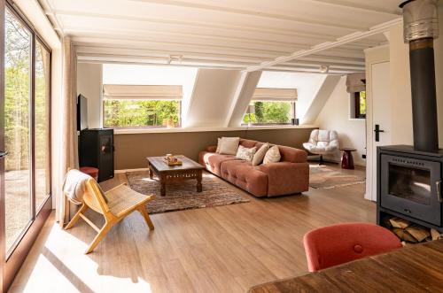 a living room with a couch and a fireplace at Boshuisje Rekem - Ember in Lanaken