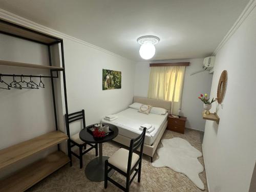 a small room with a bed and a table and chairs at Vila Reni Risi in Ksamil