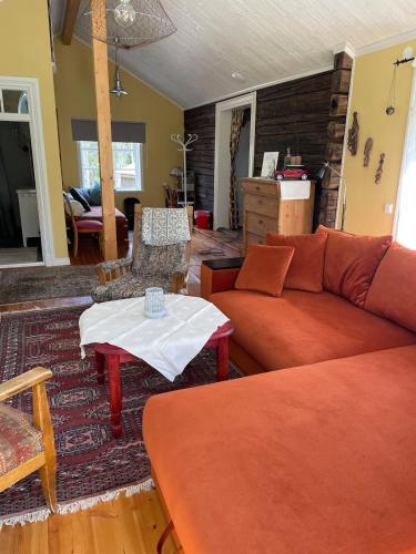 a living room with a couch and a table at Luftens timmerstuga in Sunne