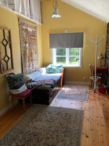 a living room with a bed and a window at Luftens timmerstuga in Sunne