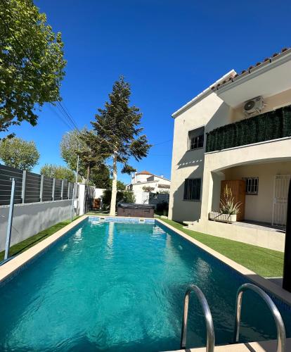 a swimming pool in front of a house at REQUESENS Playa in Empuriabrava