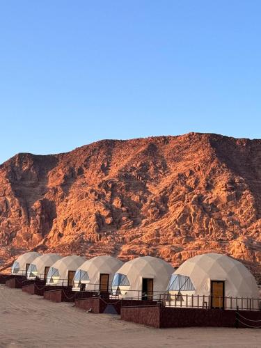 a row of domes in front of a mountain at Eram camp in Jurf ad Darāwīsh