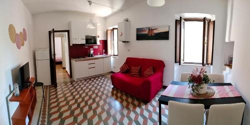a living room with a red couch and a table at A casa mia in Santa Maria degli Angeli