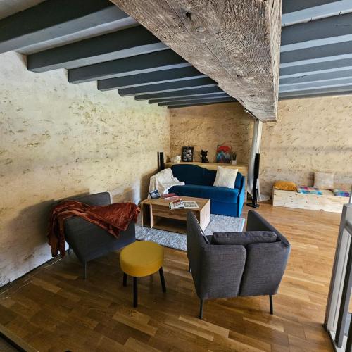 un salon avec un canapé bleu et des chaises dans l'établissement L'intendance - calme et cosy, vieilles pierres, à Saint-Félix-Lauragais