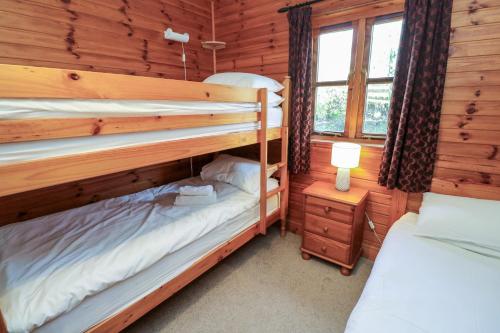 a bedroom with two bunk beds in a log cabin at Creag Mhor Lodge in Arisaig