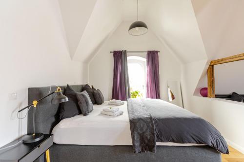 a bedroom with a white bed with purple curtains at Wohnen wie im Schloss - Alter Bahnhof von Kruft in Kruft