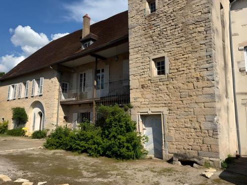 an old brick building with a balcony on the side of it at Castel Rochefort sur Nenon Jura in Rochefort-sur-Nenon