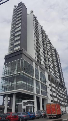 a large building with cars parked in front of it at Prestige Sky Riverfront in Kota Bharu