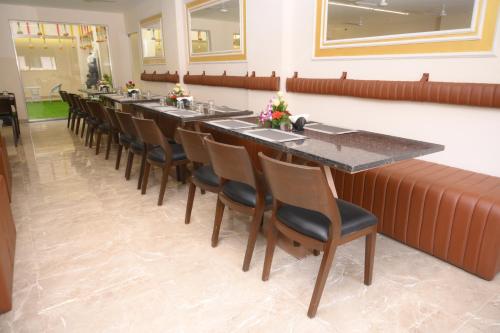 a long dining room with a long table and chairs at Zip By Spree Hotels Neelam Nakshatra in Kudal