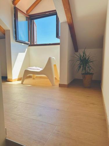 a room with a white chair and a plant at Milton holiday house in Blato
