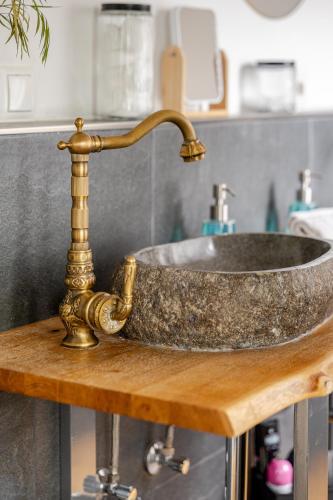 a bathroom sink with a copper faucet on a wooden table at Wohnen wie im Schloss - Alter Bahnhof von Kruft in Kruft