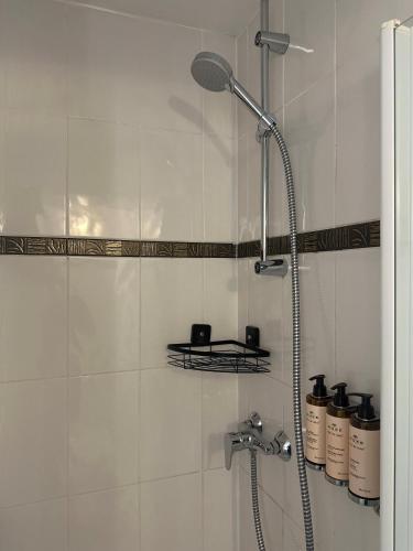 a shower in a bathroom with white tiles at Château de Bellefontaine - Teritoria in Bayeux