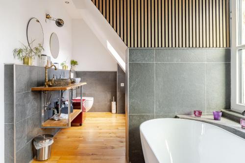 a bathroom with a tub and a toilet and a sink at Wohnen wie im Schloss - Alter Bahnhof von Kruft in Kruft