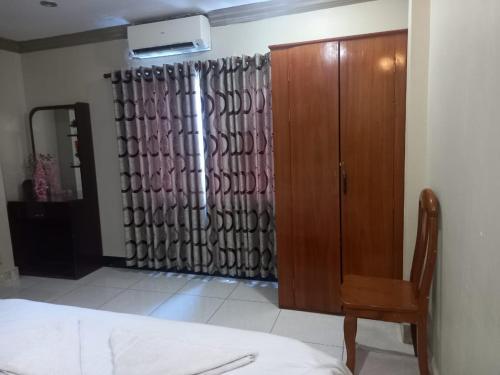 a bedroom with a closet and a dresser and a curtain at Hotel Selver Shinn & Restaurant in Phnom Penh