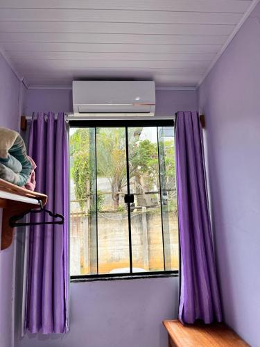 a window in a room with purple curtains at Hotel Lumiar in Lumiar