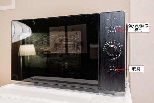 a microwave oven sitting on a counter with two arrows at 淡路町駅から徒歩1分 140平 4ldk 新宿駅12分 秋葉原5分 東京駅7分 銀座駅7分 渋谷20分 in Tokyo