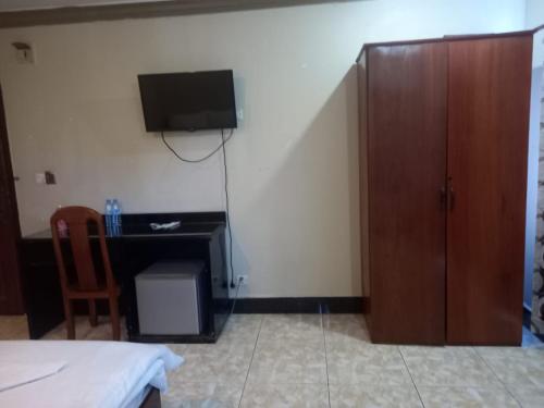 a bedroom with a bed and a tv on the wall at Hotel Selver Shinn & Restaurant in Phnom Penh