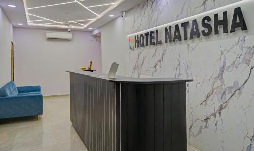 a lobby with a desk with a laptop on a wall at Hotel Natasha in Surat