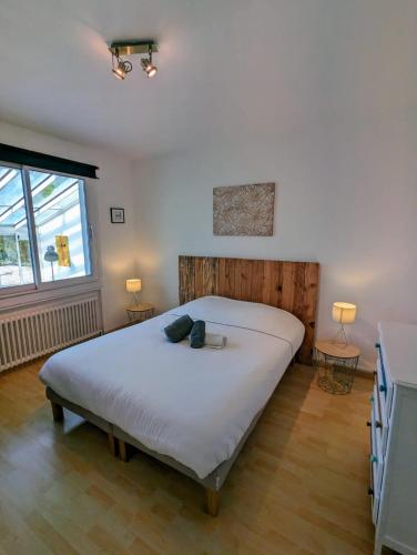 une chambre avec un grand lit blanc dans une pièce dans l'établissement Magnifique maison avec piscine, idéalement située, à La Teste-de-Buch