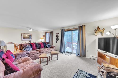 a living room with a couch and a flat screen tv at Pine Knot 62H - Retreat with Private Play Area in North Creek