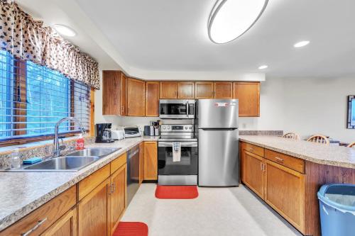 a kitchen with wooden cabinets and stainless steel appliances at Pine Knot 62H - Retreat with Private Play Area in North Creek
