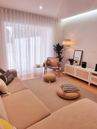 a living room with a large couch and a table at Barra B Suite Apartment - 4min walk from BEACH, Terrace in Praia da Barra