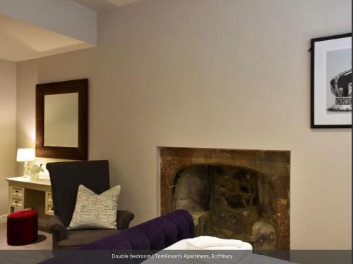 a living room with a chair and a fireplace at Tomlinsons apartments no 2 in Rothbury