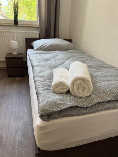 a bed with two towels on it with a window at Ferienwohnung Evelyn in Marl