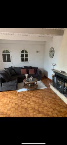 un salon avec un canapé noir et une table dans l'établissement Petite maison de campagne, à Mane
