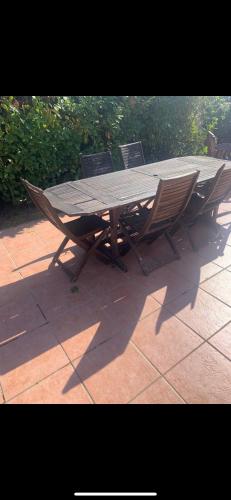 une table et des chaises en bois sur une terrasse dans l'établissement Petite maison de campagne, à Mane