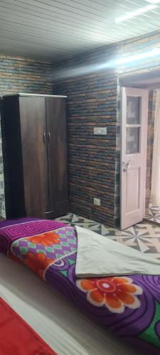 a large bed in a room with a brick wall at The Heritage jasmine lodge B&B in Shimla