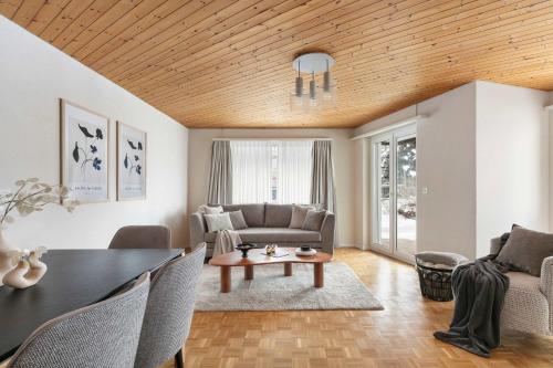 a living room with a table and a couch at Modern Alpine Stay Terrace Central Davos in Davos