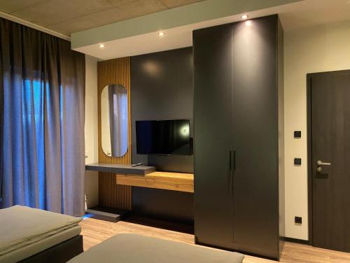 a bedroom with a bed and a tv and a cabinet at A & B Apartment und -Zimmervermietung in Tornesch