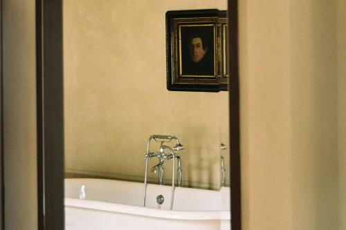 a bathroom with a bath tub with a picture of a man at Hôtel du Couvent, a Luxury Collection Hotel, Nice in Nice