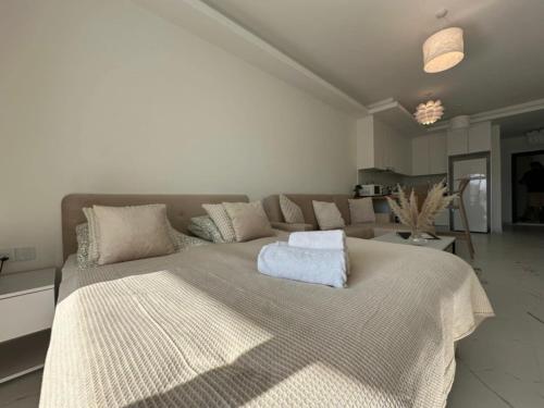 a white bedroom with a large bed and a couch at Marcellus Iskele Resort Ceasar in Larnaca