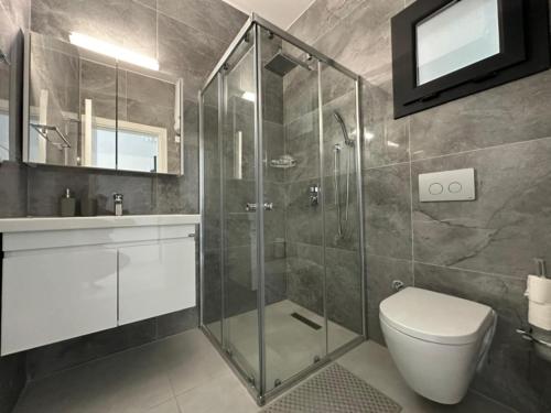 a bathroom with a shower and a toilet and a sink at Marcellus Iskele Resort Ceasar in Larnaca