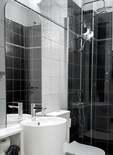 a bathroom with a shower and a toilet and a sink at StayInn Luxury Apartments in Nea Kalikratia