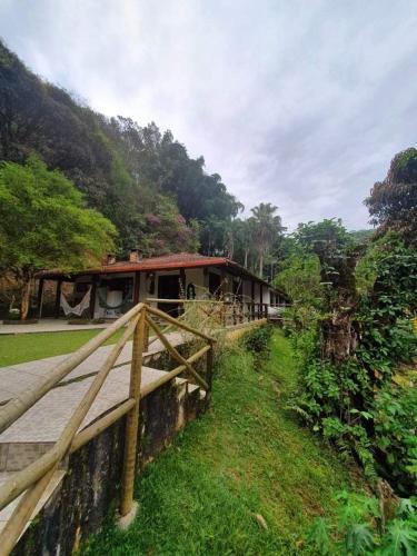 a house with a wooden fence in front of it at Suites Sítio do Sol in Penedo