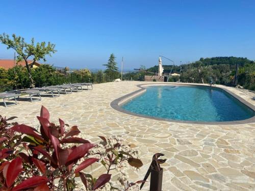 a large swimming pool with chairs and a cross at B&B Madonna Carradori Country in Offagna