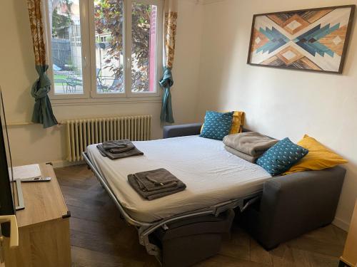 un petit lit dans une chambre avec une fenêtre dans l'établissement Les Pommiers, à Argenteuil